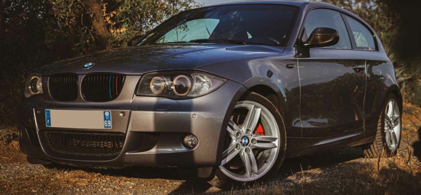 Voiture BMW Serie 1 vue de profil sur un chemin